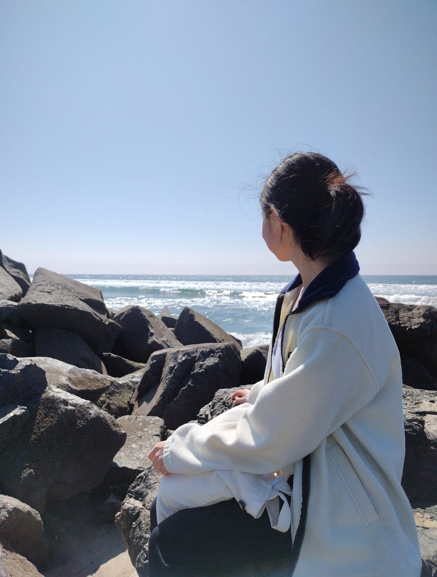 Image of me at a beach in San Diego, facing the sea ocean with my side turned towards the camera