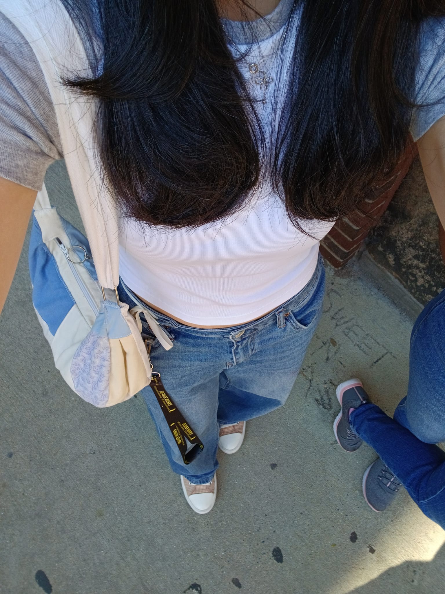 Selfie of my outfit, wearing blue wide-leg jeans and a gray ringer tee, plus a shoulder bag.